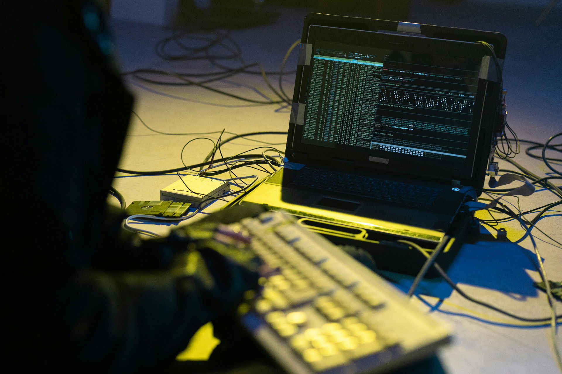 Notebook exibindo terminal com código em ambiente escuro, representando hackers e golpes digitais